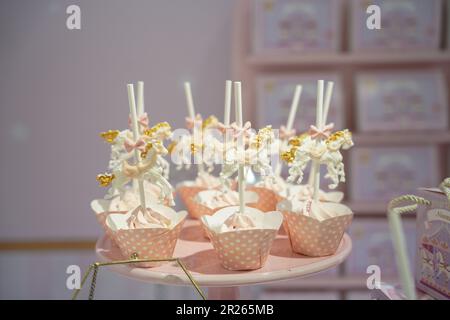 Cupcakes carino fantasia. Carosello cavallo oro e cupcakes rosa. Caramelle per feste a tema carosello per catering. Foto Stock