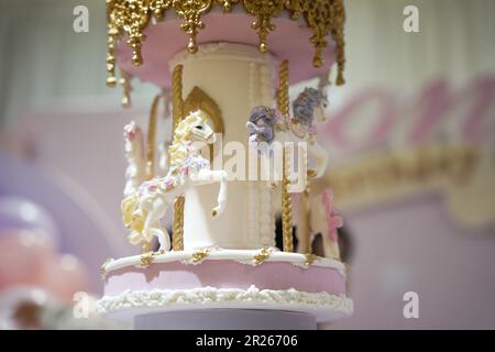 Torta di compleanno giostra decorazione closeup. Una bella torta enorme con dettagli carnevale da zucchero a velo. Torta carosello cavallo arte Foto Stock