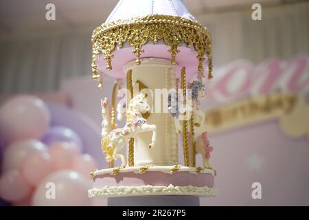 Torta di compleanno giostra decorazione closeup. Una bella torta enorme con dettagli carnevale da zucchero a velo. Torta carosello cavallo arte Foto Stock