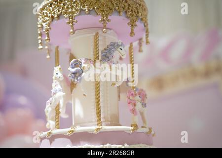 Torta di compleanno giostra decorazione closeup. Una bella torta enorme con dettagli carnevale da zucchero a velo. Torta carosello cavallo arte Foto Stock