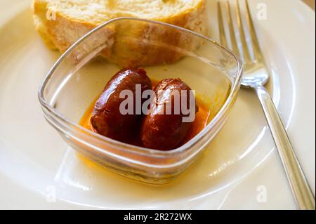 Piatto di vetro con mini tapas spagnole o antipasto, salsiccia di chorizo servita in primo piano nel ristorante Foto Stock