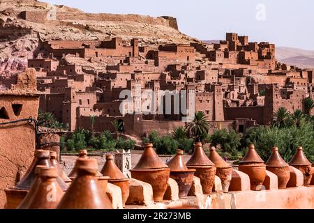 Scorcio della città costruita con la terra, con vasi di argilla in esposizione in primo piano. AIT-ben-Haddou iniziò come una città fortificata, o ksar, lungo la carava Foto Stock