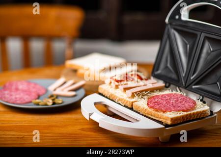 Paninoteca e paninoteca. Ingredienti diversi si trovano fianco a fianco su un tavolo di legno. Foto Stock