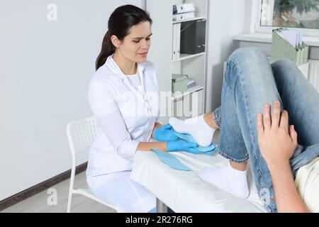 Bella intersuola ortopedica femminile che si adatta al piede del paziente in ospedale Foto Stock