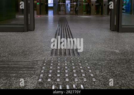 Piastrelle per pavimenti con indicatori tattili della superficie del terreno, primo piano Foto Stock