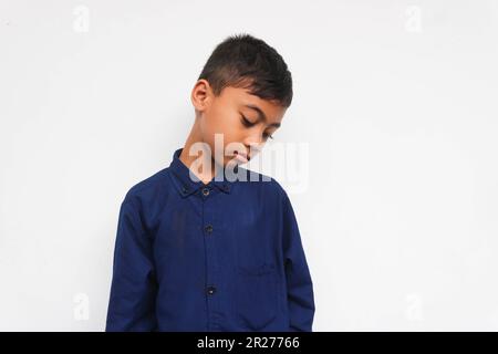 Ragazzo triste che indossa una camicia blu isolata su sfondo bianco Foto Stock