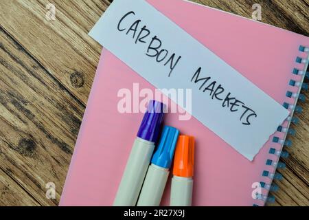 Concetto dei mercati del carbonio scrivere su note appiccicose isolate su tavola di legno. Foto Stock