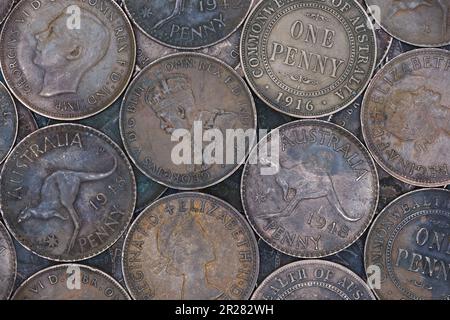 Un piatto, vista dall'alto montaggio di bronzo, vecchie monete australiane penny riempire la cornice in luce soffusa Foto Stock