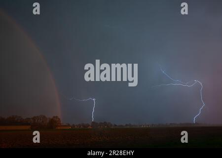 Vista spettacolare di una tempesta fulminea con arcobaleno sulle pianure Foto Stock