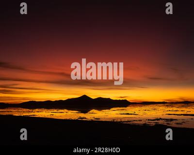 Immergiti nell'affascinante bellezza del tramonto sul Salar de Uyuni in Bolivia. Ammira gli incantevoli colori che dipingi le vaste distese di sale. Foto Stock