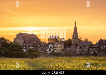 Giovedì 18th maggio 2023. Malmesbury, Wiltshire, Inghilterra - mentre il sole sorge dietro la storica abbazia, il cielo diventa giallo per eguagliare il prato delle coppe nella cittadina collinare di Malmesbury, nel Wiltshire. Credit: Terry Mathews/Alamy Live News Foto Stock