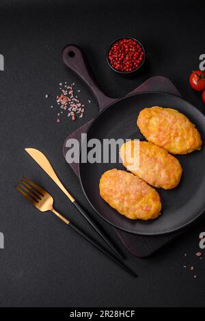 Deliziose cotolette di vapore con carote, formaggio, sale e spezie su fondo di cemento scuro Foto Stock