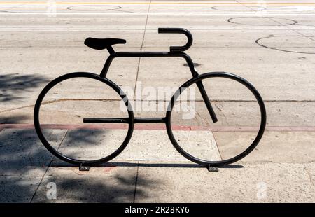 Portabiciclette a forma di bicicletta sul marciapiede Foto Stock