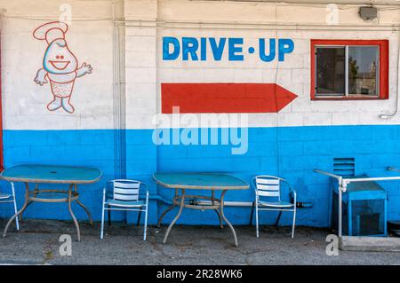 Un cartello dipinto sul muro che indica la strada per il drive through Foto Stock