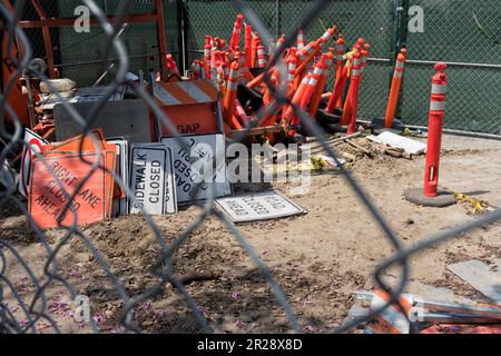 Cantiere stradale con segnaletica stradale e segnaletica stradale attraverso recinzione metallica Foto Stock