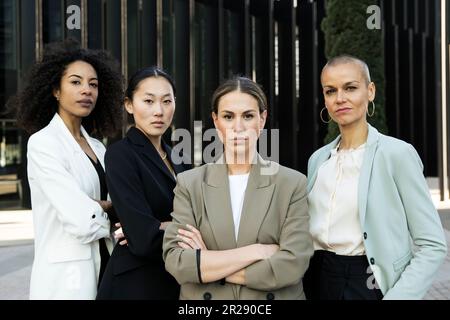 Gruppo di donne d'affari sicure e ambiziose che guardano la telecamera all'esterno. Squadra di giovani donne di successo determinate esecutive e fissando la macchina fotografica Foto Stock