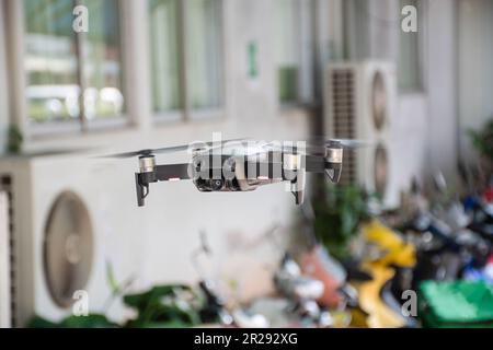 nessuno, moderno drone nero che vola in un edificio con 4 eliche, 4k fotocamera foto, e video. Il concetto per i professionisti del velivolo senza equipaggio Foto Stock