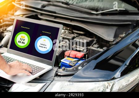 Primo piano, mano dell'uomo che digita sulla tastiera del computer portatile per controllare il funzionamento del motore dell'auto nel garage. Il motore di una vettura non si avvia. No Foto Stock