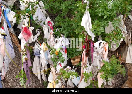 Tessuto ornato albero sacro all'ingresso della chiesa sotterranea presso le catacombe di Agia Solomoni, Paphos, Cipro. Foto Stock