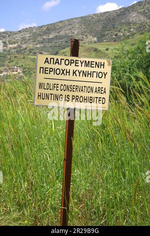 Accedi in greco e inglese dicendo Wildlife Conservation Area la caccia è vietata, Episkopi, vicino a Paphos, Repubblica di Cipro Foto Stock