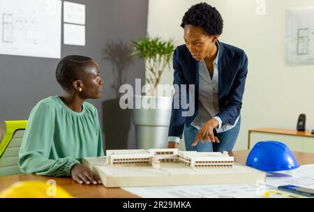 afroamericane donne architetti discutere di nuovo progetto su modello su tavolo in ufficio, copia spazio Foto Stock