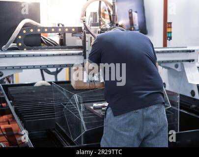 I lavoratori industriali utilizzano la macchina di taglio laser a fibre CNC. Macchine industriali per la lavorazione dei metalli Foto Stock