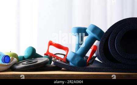 Sfondo sportivo con tavola in legno con manubri e sfondo con tenda Vista frontale. Foto Stock