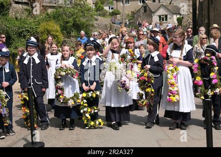 Bisley, Glos, Regno Unito. 18th maggio, 2023. In un'attività tradizionale del Cotswold, i bambini della scuola elementare Blue Coat festeggiano il giorno dell'Ascensione sfilando attraverso il villaggio. I bambini indossano uniformi in stile vittoriano tradizionale. I ghirlande di fiori sono trasportati alle campane che poi decorano. La tradizione iniziò nel 1863 quando il Vicario, il reverendo Keble rese grazie per l'acqua pulita dei villaggi. Credit: JMF News/Alamy Live News Foto Stock