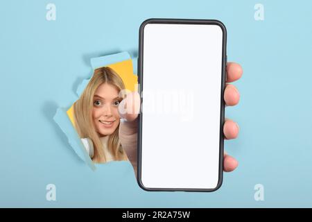 donna simpatica che mostra lo smartphone con schermo bianco vuoto Foto Stock