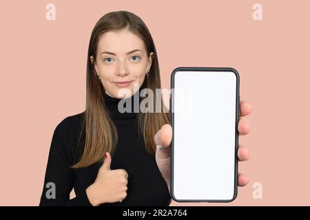 donna simpatica che mostra lo smartphone con schermo bianco vuoto Foto Stock