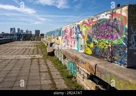Cima di graffiti coperti e derelitti Linnahall di epoca sovietica con uno sfondo dello skyline di Tallinn dominato dai grattacieli di Tallinn, Estonia Foto Stock
