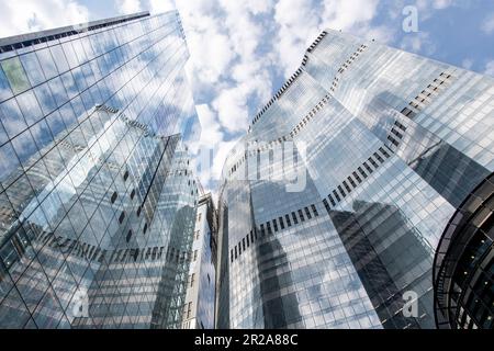Londra, Inghilterra - agosto 2022; vista dall'angolo basso della facciata in vetro e acciaio di alcuni degli edifici di architettura moderna per uffici Foto Stock