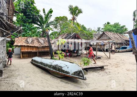 Una casa tradizionale nelle Isole Salomone è una notevole esposizione di artigianato locale e l'adattamento all'ambiente naturale. Elevata su robuste palafitte di legno, la casa sorge graziosamente in mezzo al lussureggiante paesaggio tropicale. La struttura principale è costruita utilizzando legname proveniente da foreste vicine, accuratamente assemblate per creare un solido telaio. Il tetto, intricately thatched con le foglie di palma, fornisce uno scudo durevole ed efficace contro le piogge tropicali e le pareti dure di Sun.The, sapientemente tessute da bambù o tavole di legno, permettendo che brezze delicate fluiscano attraverso e fornendo la ve Foto Stock