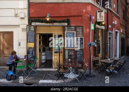 Straßencafe, Italien, März 2023 Straßenszene mit Touristen und Läden in einer schattigen Gasse am Mittag Foto Stock