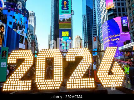 New York, Stati Uniti. 18th maggio, 2023. Le persone guardano i cartelloni con i logo ufficiali della Coppa del mondo FIFA 2026 New York/New Jersey in un evento di lancio a Times Square. L'evento ha svelato i temi ufficiali delle partite dello stadio MetLife: 'We are NYNJ' e 'We are 26'. La più alta competizione calcistica del mondo ha già in programma di ospitare 8 partite nella zona di New York/New Jersey e gli organizzatori locali vogliono ospitare anche qui la partita finale. Credit: Enrique Shore/Alamy Live News Foto Stock