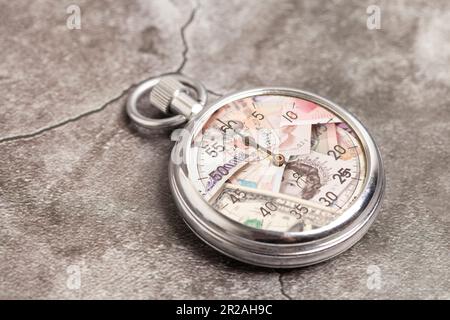 Cronometro con valute internazionali all'interno. Il tempo è concetto di denaro, illustrazione Foto Stock