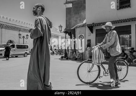Uomini che camminano nella strada della Medina, Marrakech (Marocco) 2023. Immagine in bianco e nero. Foto Stock