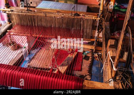 Tessitura artigianale locale con cornice tradizionale e creazione di tessuti fatti a mano nel vecchio mercato Kasbah. Marrakech, Marocco Foto Stock