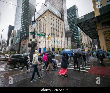 I turisti sulla Fifth Avenue a New York con i loro ombrelli di fronte al negozio di Tiffany & Co. Riaperto di recente domenica 30 aprile 2023. Il tempo dagli Stati Uniti sudorientali e dalla valle del Mississippi è arrivato a New York garantendo una domenica sgargiante. (© Richard B. Levine) Foto Stock