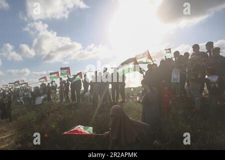 Città di Gaza, territori Palestinesi. 18th maggio, 2023. I palestinesi partecipano a una "marcia della bandiera" lungo il confine con Israele a est della città di Gaza in risposta alla Giornata di Gerusalemme, un evento annuale durante il quale i nazionalisti israeliani celebrano la conquista israeliana di Gerusalemme est dopo la guerra dei sei giorni del 1967. Credit: Mohammed Talatene/dpa/Alamy Live News Foto Stock