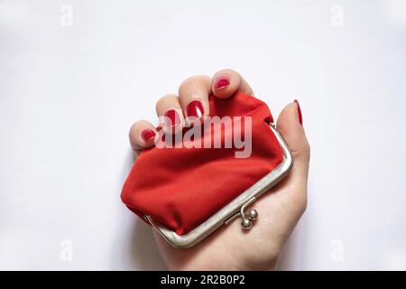 portafoglio rosso vecchio e mano femmina su sfondo isolato primo piano Foto Stock