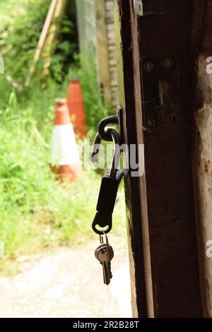 Lucchetto e chiave appesi alla porta dell'azienda agricola Foto Stock