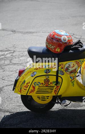Vespa d'epoca su misura con casco dipinto a mano e decorata con iconografia popolare siciliana in Sicilia, Italia. Foto Stock