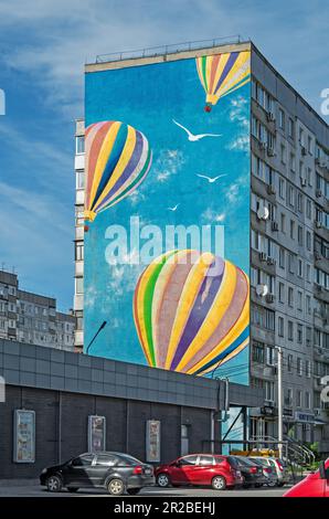 Dnipro, Ucraina - 07 maggio 2023: Murale romantico con mongolfiere sul lato di un edificio a più piani in una zona residenziale della città Foto Stock