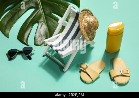 Accessori da spiaggia con foglia di palma su fondo menta Foto Stock