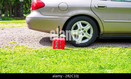 Un distributore di benzina seduto accanto a un'auto Foto Stock