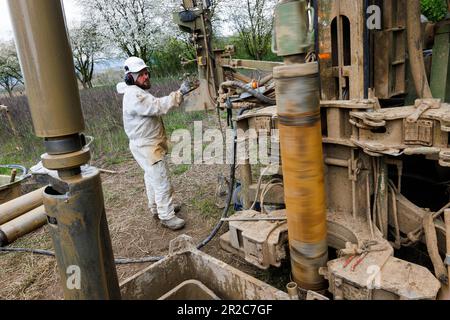 PRODUZIONE - 19 aprile 2023, Baden-Württemberg, Offenburg: Un dipendente di una società di perforazione perfora un tubo nel terreno per prelevare campioni di terreno. Quando la Deutsche Bahn costruisce un nuovo tunnel o interviene in altro modo sul terreno, estrae grandi quantità di materiale scavato dalla terra durante il processo, diversi milioni di tonnellate all'anno solo in Germania. Con una nuova idea di start-up, DB sta restituendo al ciclo economico molte tonnellate di sabbia, ghiaia, argilla e pietra naturale e vuole quindi conservare le risorse: La startup aziendale Erdpool, che offre materie prime minerali provenienti da progetti di costruzione Foto Stock