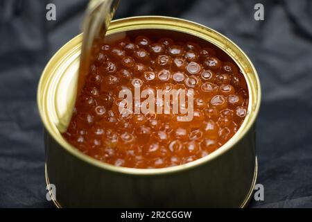 lattina di ferro con caviale rosso su sfondo isolato primo piano Foto Stock