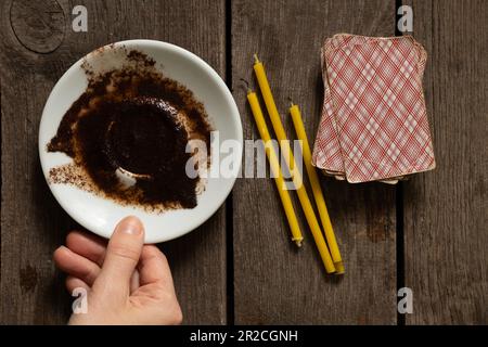 caffè macinato su un piattino per raccontare la fortuna carte e candele sul tavolo, fortuna raccontare la fortuna su caffè macinato Foto Stock