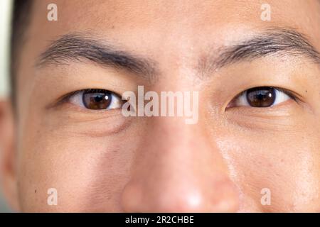Primo piano ritratto degli occhi di un medico maschile asiatico felice inalterato sorridendo alla fotocamera in ospedale Foto Stock